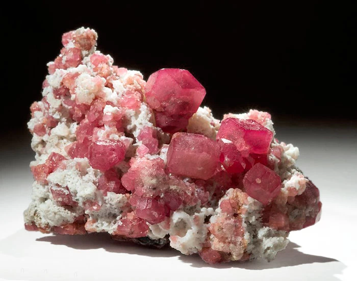 rough garnet mineral on display in a museum display cabinet