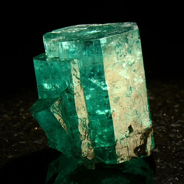 green beryl mineral variety emerald in a museum display cabinet