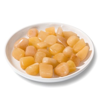 colourful yellow aventurine tumbled stones on a round white saucer